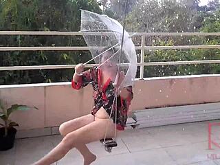 En hemmafru hänger sig åt att svänga utan underkläder medan hon söker skydd från regn under ett paraply i en klassisk helkroppsvideo